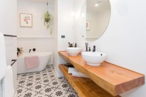 ein Badezimmer mit zwei Waschbecken und einer Badewanne und einem Spiegel in der Unterkunft Anzac North Loft - 4 Bedrooms & 2 Free Car Parks in Auckland + 23 Fotos