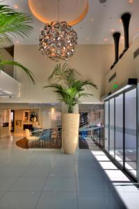 a lobby with a large plant in a large vase at Livadhiotis City Hotel in Larnaka