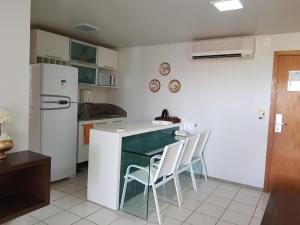 cocina con nevera, mesa y sillas en Marulhos resort en Porto De Galinhas
