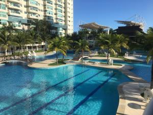 a large swimming pool with palm trees and buildings at Apartamento Bora Bora in Rio de Janeiro