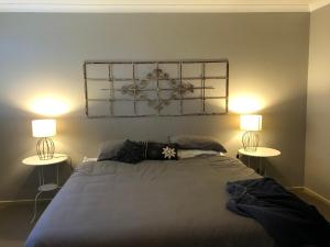a bedroom with a bed with two lamps on it at The Old Coolstore - Braeburn Apt in Merricks North
