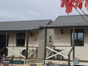 a house with a metal roof and a patio at Rosedale Cottages in Twizel
