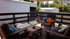 a patio with two chairs and a coffee table on a deck at Pebbles Beach Retreat in Cowes
