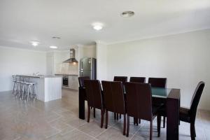 a dining room with a table and chairs and a kitchen at Jindabyne Executive in Jindabyne