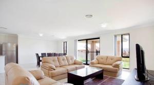 a living room with two couches and a tv at Jindabyne Executive in Jindabyne