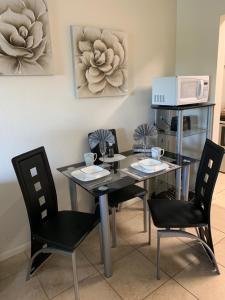 comedor con mesa, sillas y microondas en Sienna Park Apartments, en Sarasota