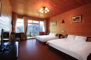 a bedroom with two beds and a large window at Yun Meng Xianjing Homestay in Ren'ai