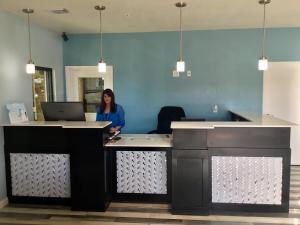 a woman standing at a desk with a laptop at Days Inn by Wyndham Freeport in Freeport
