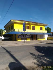 a yellow building with a sign in front of it at Apartamento itapoá 30 in Itapoa