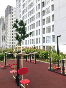 a park with red chairs and a tree in front of a building at M-Town Residence Gading Serpong by Taslim Property in Tangerang