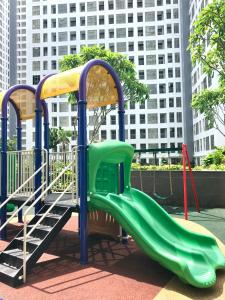 a playground with a green slide in a city at M-Town Residence Gading Serpong by Taslim Property in Tangerang
