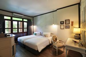 曼谷的住宿－曼谷拉威坎拉亞酒店，一间卧室配有一张床、一把椅子和一张书桌