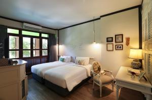 ein Schlafzimmer mit einem Bett, einem Stuhl und einem Schreibtisch in der Unterkunft The Raweekanlaya Bangkok in Bangkok + 37 Fotos