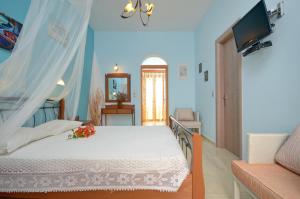 a bedroom with a bed and a television in it at Orama Studios in Agia Anna Naxos