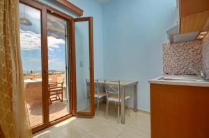 a kitchen with a balcony with a table and chairs at Orama Studios in Agia Anna Naxos
