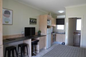 a kitchen with a counter and some stools in it at Tumut Apartments in Tumut
