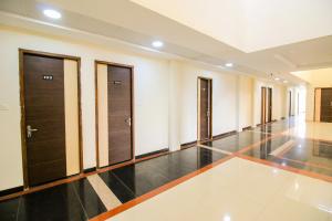 a hallway with wooden doors and a tile floor at Namastay Welcome Home in Ratlām