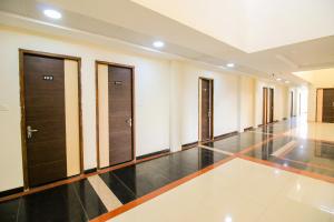 - un couloir avec des portes en bois et du carrelage dans l'établissement Namastay Welcome Home, à Ratlām