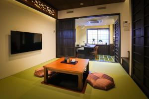 a living room with a table and a television at Kyonoyado Gekkoan in Kyoto