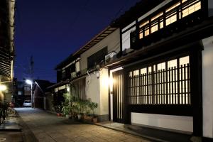a building with lit windows on a street at night at Kyonoyado Gekkoan in Kyoto