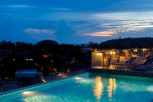 a swimming pool at night with a house at Ozone Condotel in Kata Beach