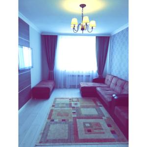 sala de estar con sofá y ventana en Best apartment on Sauran Towers, en Astana