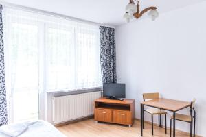 a bedroom with a bed and a table with a television at SCSK Brzeźno in Gdańsk