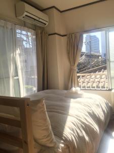 a bedroom with a bed and a large window at COCO Nakameguro301 in Tokyo