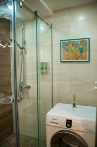 La salle de bains est pourvue d'une douche et d'un lave-linge. dans l'établissement Apartment Near Church, à Tbilissi