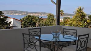 a table and chairs on a balcony with a view of the ocean at Beachy Head 61 in Plettenberg Bay