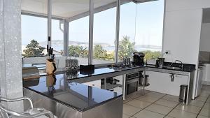a kitchen with a counter top with a large window at Beachy Head 61 in Plettenberg Bay