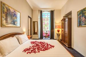 a bedroom with a bed with a pile of rose petals on it at Rome Garden Hotel in Rome