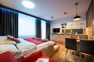 a bedroom with a bed and a desk and a television at 4Roses Apartments in Starý Smokovec