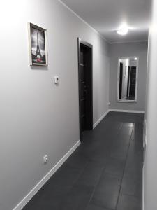 a hallway with a black door and a mirror at Arkadia Hostel in Mława