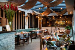 a restaurant with tables and chairs with wine bottles at Bisma Eight - CHSE Certified in Ubud