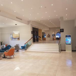 a lobby with stairs and chairs in a building at Paradise Bay Resort in Mellieħa +37 photos