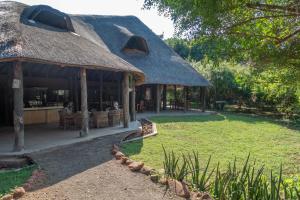 une cabane avec un toit en gazon et une cour dans l'établissement Munga Eco-Lodge, à Livingstone