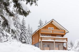 uma cabana de madeira na neve com árvores em Holiday Home Kuća za odmor LEA - Ravna Gora em Ravna Gora