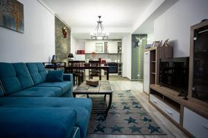 ein Wohnzimmer mit einem blauen Sofa und einem Tisch in der Unterkunft Blue SKY Resort Colina Marei in Sinaia
