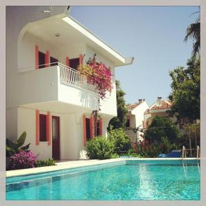 a house and a swimming pool in front of a house at Flower Villa Apart in Kemer