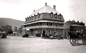 une photo en noir et blanc d'un grand bâtiment avec un cheval et une calèche dans l'établissement Highlands Hotel, à Mittagong