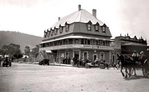 米塔贡Highlands Hotel的一张黑白相间的一张大建筑照片,上面有马和马车