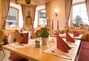 a dining room with a long wooden table with candles at Hotel Bräuwirt in Kirchberg in Tirol