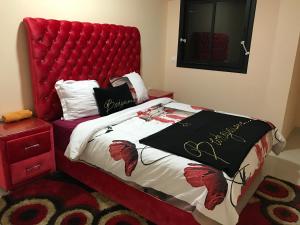 Una cama roja con cabecero rojo en un dormitorio en Recidence Ires 66, en Tánger