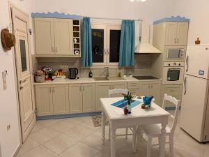 uma cozinha com uma mesa branca e um frigorífico branco em Caldera Boutique em Astypalaia