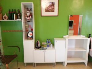 a room with a green wall and a white cabinet at 悦來民宿 台東縣民宿334號 in Taiping