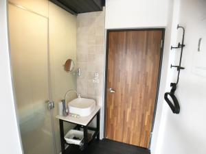 a bathroom with a wooden door and a sink at Wu Ting Stay in Hualien City