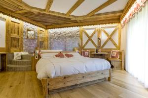 1 dormitorio con 1 cama en una habitación con techos de madera en Chalet Pineta relax location, en Canazei