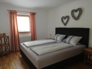 バート・ホーフガシュタインにあるSchmalzgrubengutのベッドルーム1室(ベッド1台、壁にハート2つ付)