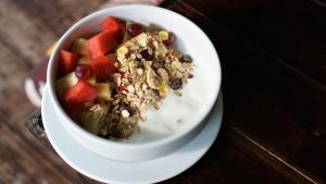 a bowl of cereal with fruit and nuts on a plate at Morning Star Resort in Baan Tai